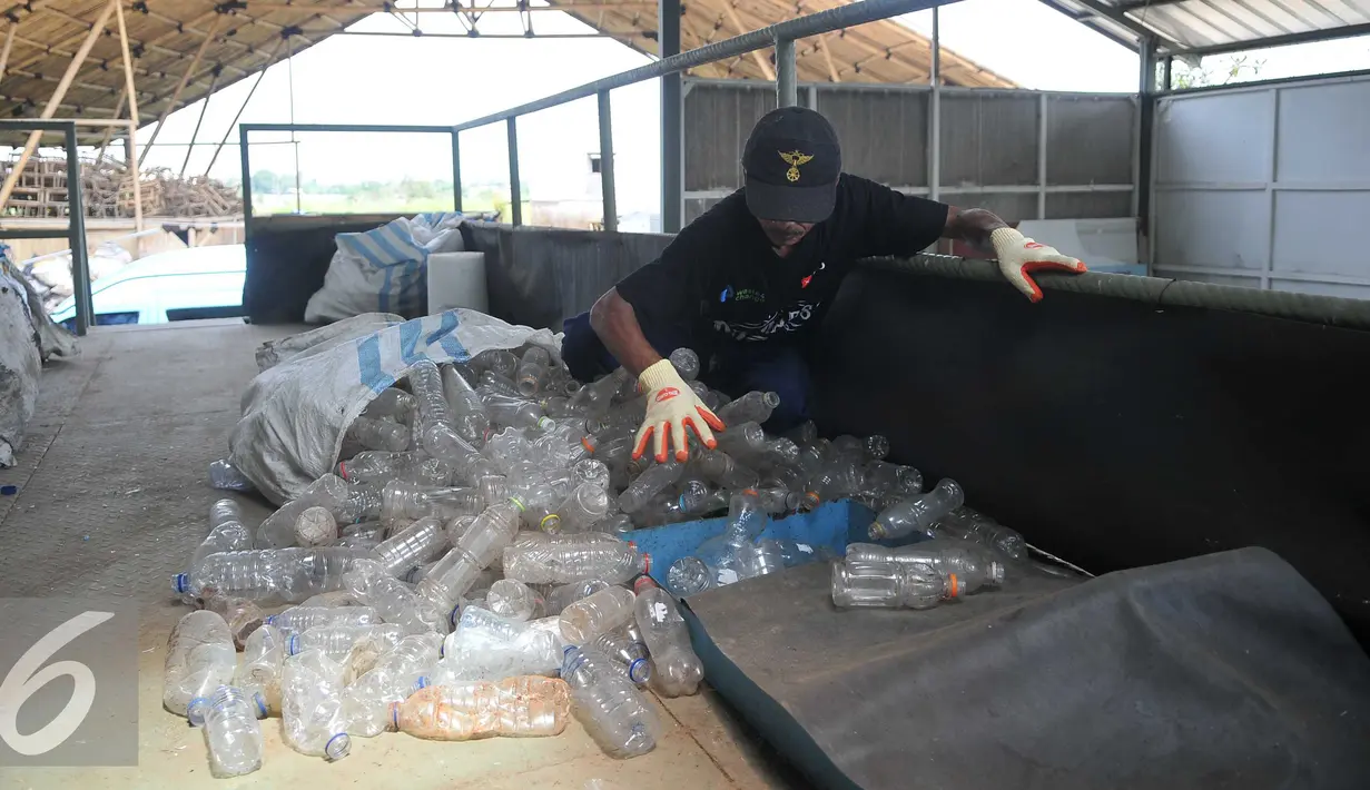 Pekerja memasukan botol plastik kedalam alat potong plastik di Perumahan Vida, Bekasi (19/3). Limbah botol plastik dimanfaatkan menjadi bahan mentah yang bernilai ekonomis dan mengurangi dampak pencemaran lingkungan. (Liputan6.com/Gempur M Surya)