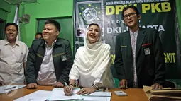 Mischa Hasnaeni Moein atau biasa disebut "Wanita Emas" saat mengisi daftar tamu di DPW PKB DKI Jakarta, Senin (11/4). Kedatangan wanita emas itu untuk mengambil formulir pendaftaran bakal calon gubernur DKI Jakarta dari PKB. (Liputan6.com/Faizal Fanani)