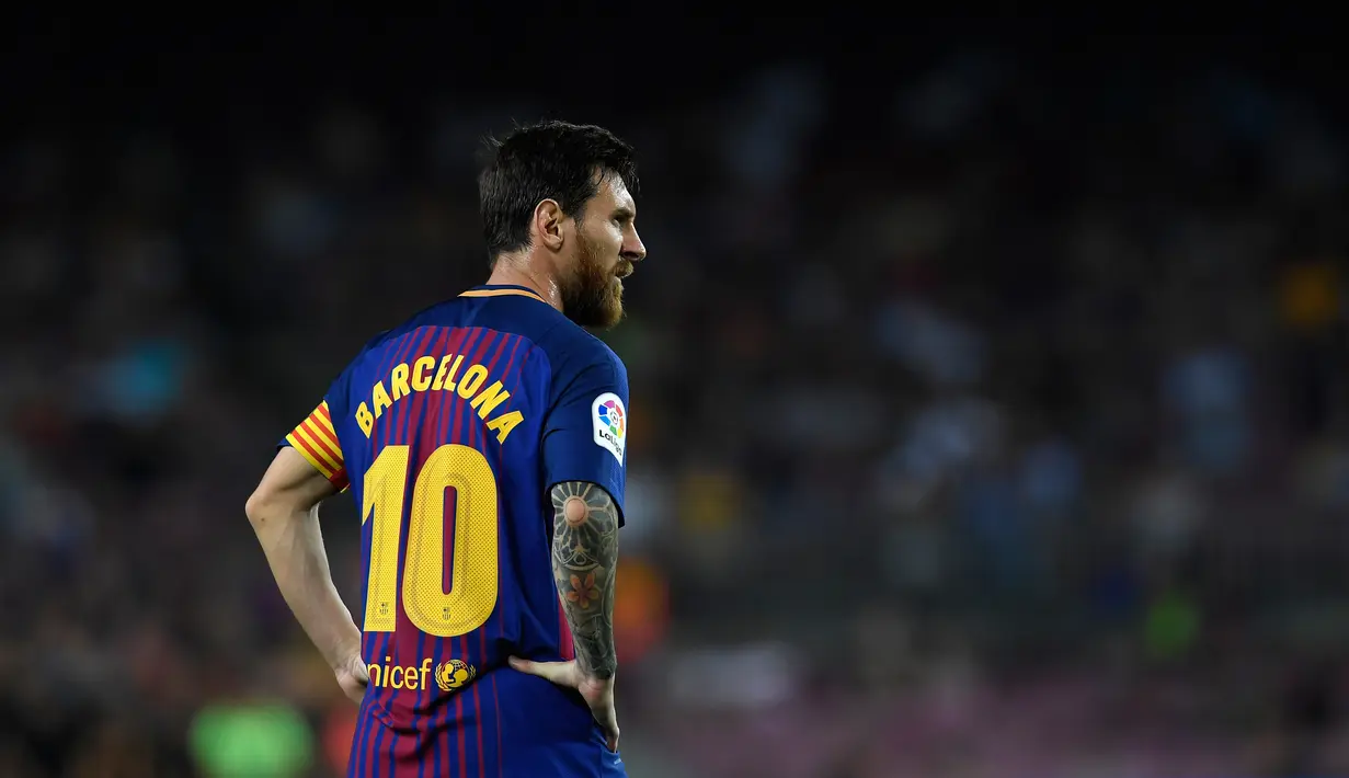 Striker Barcelona, Lionel Messi mengenakan jersey khusus dalam laga pekan pertama Liga Spanyol melawan Real Betis di Stadion Camp Nou, Minggu (20/8). Aksi itu sebagai bentuk duka cita atas serangan teror di pusat Kota Barcelona pekan lalu (LLUIS GENE/AFP)