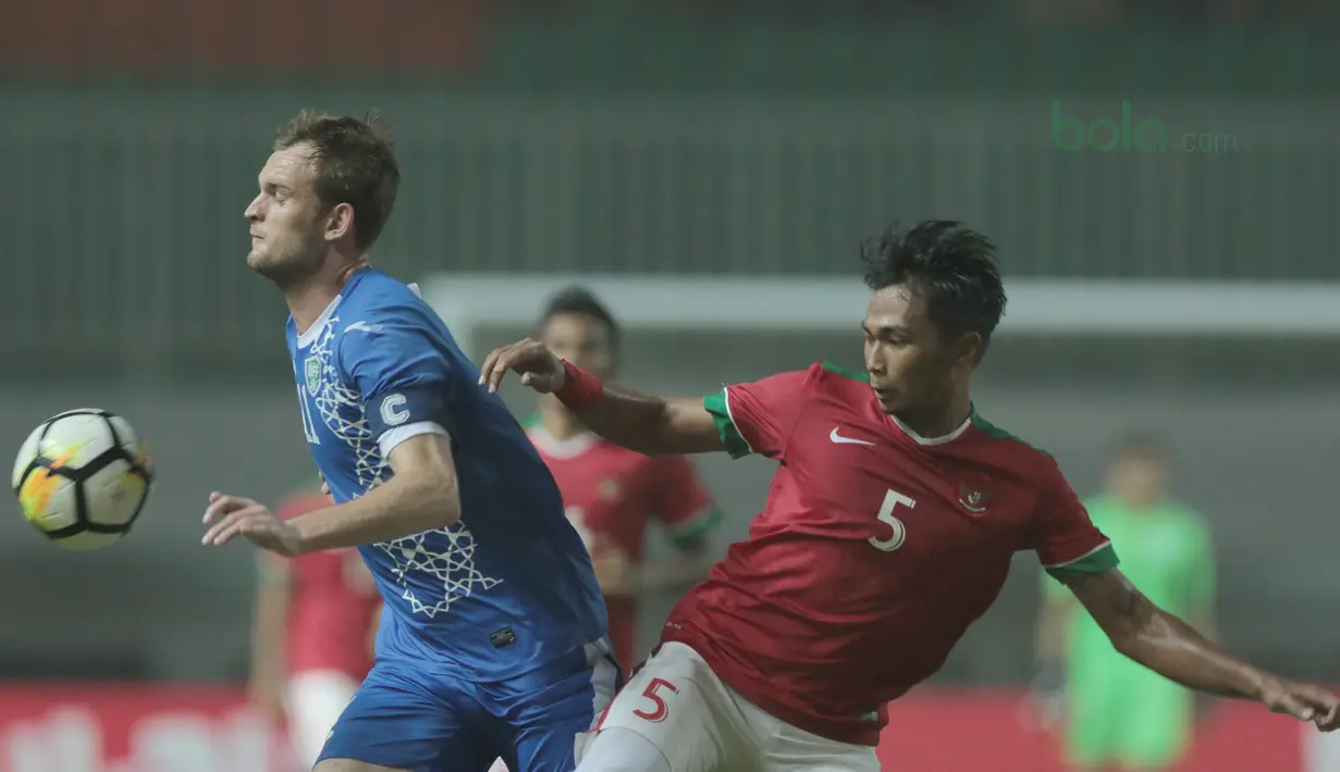 Duel pemain timnas Indonesia U-23, Bagas Adi Nugroho (kanan) dengan pemain Uzbekistan pada laga PSSI Anniversary Cup 2018 di Stadion Pakansari, Bogor, (03/5/2018). Indonesia U-23 bermain imbang 0-0. (Bola.com/Nick Hanoatubun)