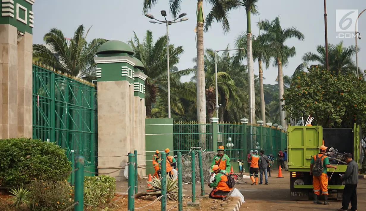 Petugas mengangkut sampah sisa bentrok antara mahasiswa dan polisi dalam unjuk rasa di depan Gedung DPR RI, Jakarta, Rabu (25/9/2019). Bentrokan pada Selasa (24/9/2019) menyisakan sampah yang memenuhi kawasan di sekitar Gedung DPR. (Liputan6.com/Immanuel Antonius)