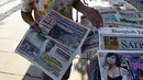 Penjual menunggu pembeli surat kabar dengan berita utama kecelakaan helikopter pemilik Leicester City Vichai Srivaddhanaprabha di Bangkok, Senin (29/10). Bos Leicester City tewas ketika helikopternya jatuh dan terbakar. (Lillian SUWANRUMPHA/AFP)