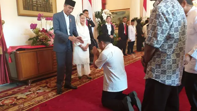 Seorang warga sujud saat bersamalan dengan Jokowi dan Iriana