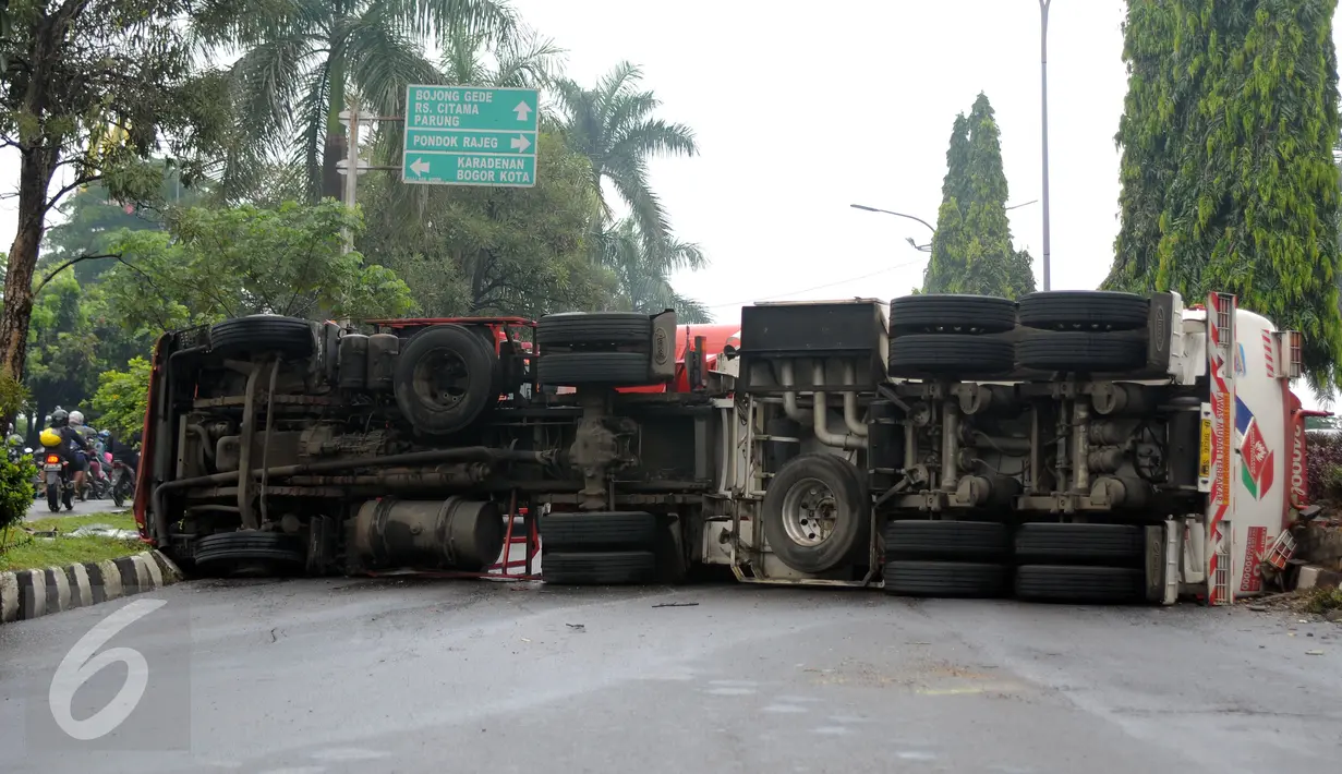 Kondisi sebagian ruas Jalan Tegar Beriman Kabupaten Bogor yang tertutup truk tangki BBM yang terbalik Jumat (15/4/2016). Menurut warga, truk tangki bermuatan 24.000 liter tersebut terbalik sekitar pukul 05.00 dini hari. (Liputan6.com/Helmi Fithriansyah)