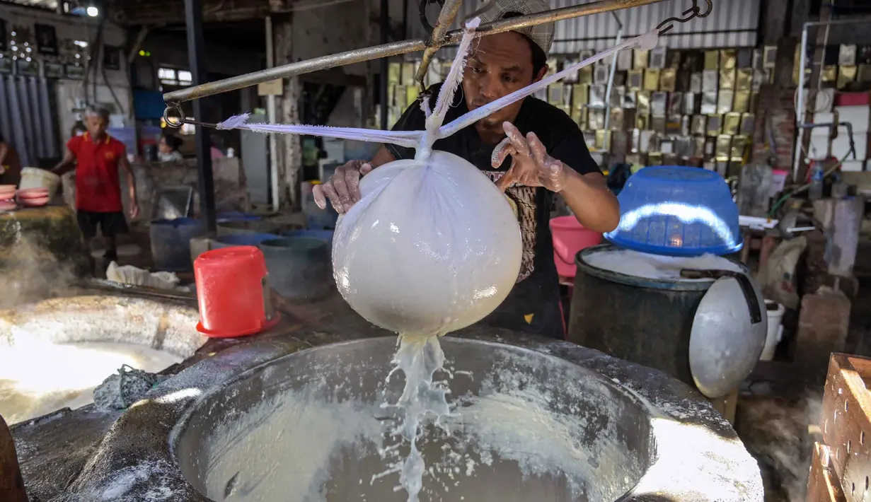 Para perajin berharap pemerintah dapat mengambil langkah untuk menjaga stabilitas harga kedelai agar keberlangsungan usaha kecil tetap terjaga di tengah fluktuasi harga bahan baku. Tampak dalam foto, seorang pekerja menyaring kedelai giling yang sudah dimasak untuk mendapatkan ekstraknya di sebuah pabrik tahu, Surabaya, Jawa Timur pada Kamis 5 Februari 2026. (JUNI KRISWANTO/AFP)