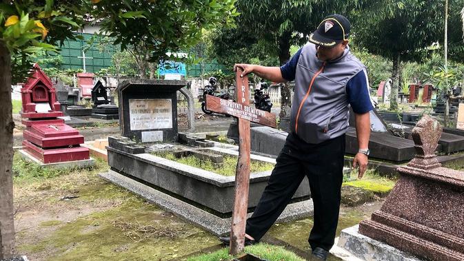 Pengurus makam saat hendak memasang kembali kayu penanda yang sudah sedikit terbakar. (Foto : Liputan6.com/KRjogja.com/Harminanto)