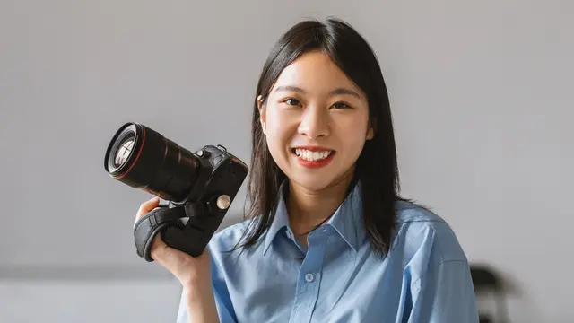 memegang kamera tersenyum bekerja karir