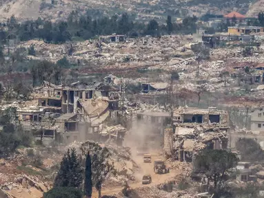 Foto menunjukkan kendaraan militer Israel melaju di antara rumah-rumah yang hancur di Lebanon Selatan dekat perbatasan dengan Israel, pada Senin 27 April 2026. (Jalaa MAREY/AFP)