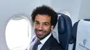 Penyerang Timnas Mesir, Mohamed Salah tersenyum saat berada di pesawat di Kairo (10/6). Pemain Liverpool ini masih dalam masa pemulihan cedera bahu yang dideritanya pada final Liga Champions melawan Real Madrid. (AFP Photo/Karim Jaafar)