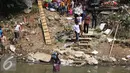 Seorang warga membawa barang miliknya menyeberangi kali Ciliwung usai penggusuran di Kampung pulo, Jakarta, Jumat (21/8/2015). Penggusuran terkait rencana Pemprov DKI Jakarta yang akan melakukan normalisasi Kali Ciliwung. (Liputan6.com/Gempur Surya)
