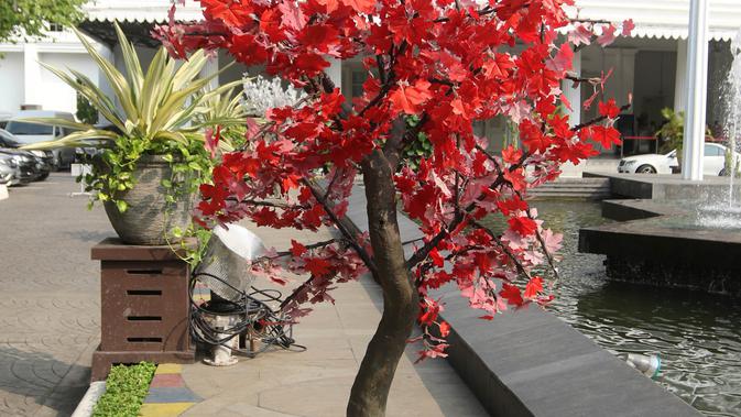 Penampakan pohon imitasi berwarna merah yang terpasang di halaman Balai Kota DKI Jakarta, Senin (4/6). (Liputan6.com/Arya Manggala)