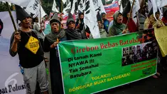 Massa membentangkan spanduk ketika menggelar aksi protes di Istana Negara, Jakarta, Senin (10/10). Mereka menolak pembukaan kembali bongkar muat batubara di Pelabuhan Cirebon yang akan mengakibatkan banyak warga terkena ISPA. (Liputan6.com/Faizal Fanani)