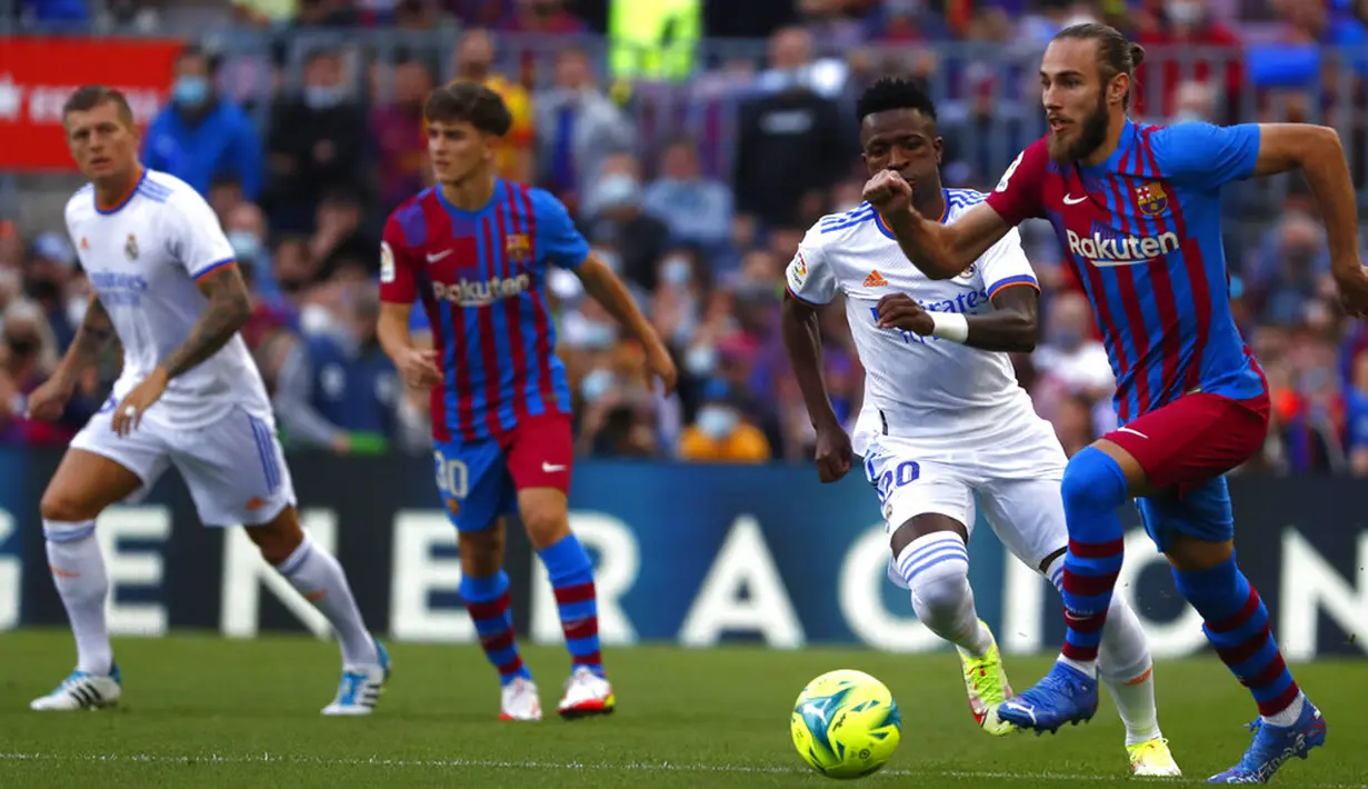 Pemain Barcelona Oscar Mingueza (kanan) mengontrol bola saat melawan Real Madrid pada pertandingan La Liga Spanyol di Stadion Camp Nou, Barcelona, Spanyol, Minggu (24/10/2021). Real Madrid menang 2-1. (AP Photo/Joan Monfort)