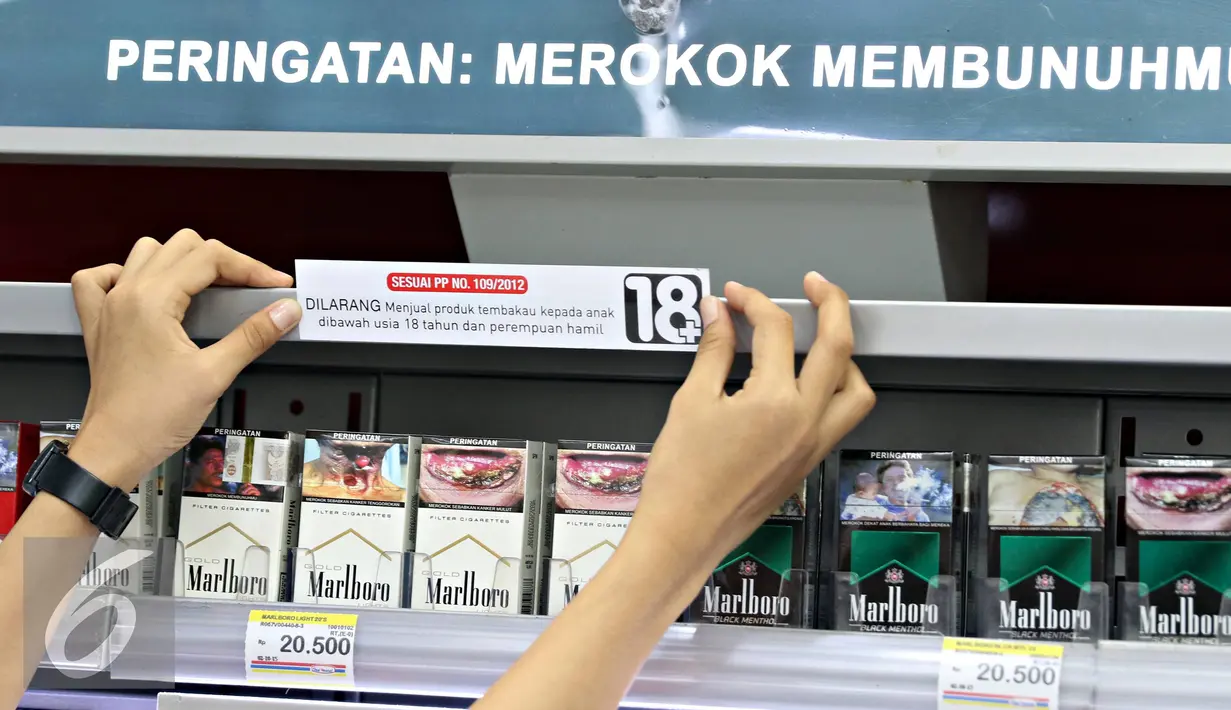 Petugas menempelkan papan peraturan penjualan rokok di gerai Indomaret, Jakarta, Selasa (3/11). Program untuk meningkatkan kesadaran masyarakat akan pelarangan pembelian produk tembakau oleh anak di bawah 18 tahun. (Liputan6.com/Immanuel Antonius)