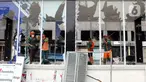 Petugas PPSU membersihkan sisa pecahan kaca di halte transjakarta Senen, Jakarta, Jumat (9/10/2020). Unjuk rasa menentang disahkannya Omnibus Law UU Cipta Kerja berujung aksi anarkis merusak berbagai fasilitas umum pada Kamis malam (8/10). (Liputan6.com/Helmi Fithriansyah)