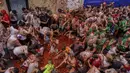 Orang-orang yang bersuka ria saling melempar tomat selama pesta pertarungan tomat tahunan "Tomatina", di desa Bunol dekat Valencia, Spanyol, Rabu (28/8/2024).  (AP Photo/Alberto Saiz)