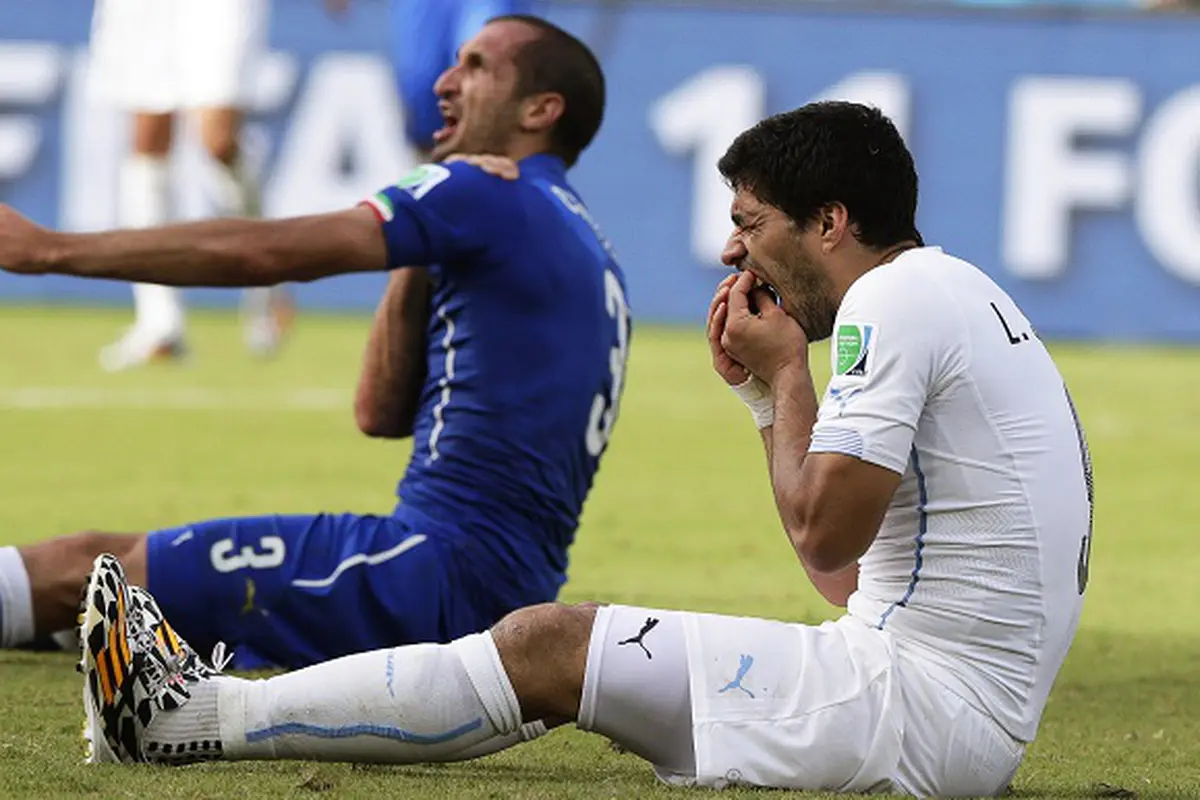 Giorgio Chiellini (kiri) mengklaim bahwa ia digigit oleh Luis Suarez (kanan) dalam pertandingan babak penyisihan antara Italia dan Uruguay Piala Dunia FIFA 2014 grup D di Estadio Arena das Dunas di Natal, Brasil, 24 Juni 2014. EPA / Emilio Lavandeira JR