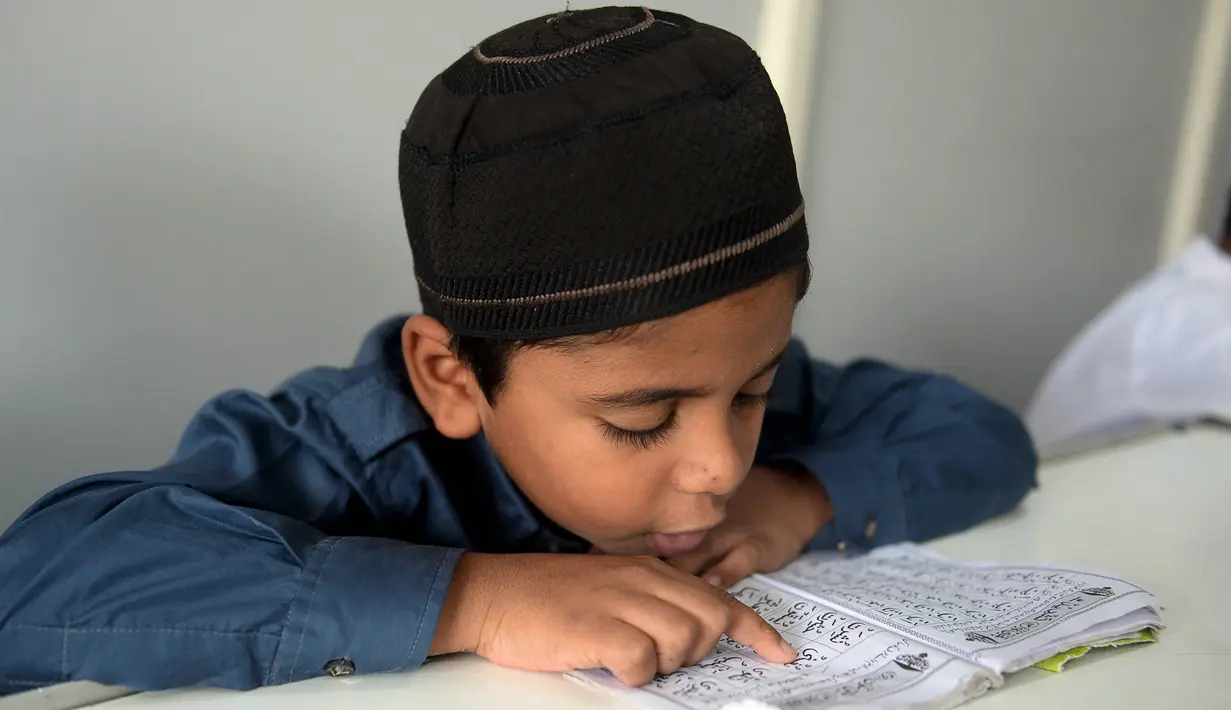 Seorang siswa muslim membaca Alquran selama bulan suci Ramadhan di Madinatul Uloom Tahfeez ul Quran, Hyderabad, India, Kamis (7/4/2022). (NOAHSELAM/AFP)