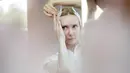 Penari dari Berlin State Ballet meletakkan bulu angsa pada rambutnya saat bercermin di atas kapal pesiar sebelum tur pusat kota di Berlin, Jerman, Kamis (10/6/2021). Pertunjukan itu diikuti oleh banyak orang di sepanjang rute . (Christoph Soeder/dpa via AP)