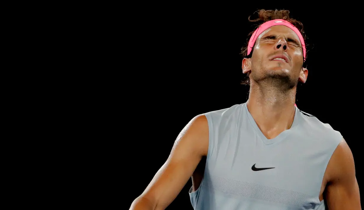 Petenis Spanyol, Rafael Nadal menahan sakit saat bertanding melawan petenis Kroasia, Marin Cilic di perempat final Australia Terbuka 2018, Selasa (23/1). Nadal harus tersingkir di Australia Terbuka karena mengalami cedera paha atas. (AP/Dita Alangkara)