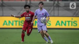 Pemain Indonesia All Star U-20 Andre Oktaviansyah (kiri) berebut bola dengan pemain FC Barcelona U-18 pada pertandingan International Youth Championship 2021 di Jakarta International Stadium, Jakarta, Rabu (13/4/2022). Pertandingan berakhir imbang 0-0. (Liputan6.com/Faizal Fanani)