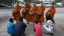 Warga berdoa usai memberikan makanan kepada para biksu Buddha yang memakai pelindung wajah untuk melindungi diri dari virus corona COVID-19 saat mengumpulkan sedekah di Bangkok, Thailand, Selasa (31/3/2020). Hingga 30 Maret 2020, kasus positif COVID-19 di Thailand ada 1.524. (AP Photo/Sakchai Lalit)