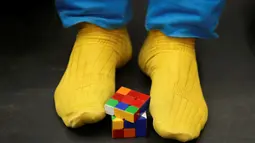 Peserta memutar rubik menggunakan kaki pada Kejuaraan Rubik Eropa  di Praha , Republik Ceko , (15/7). Kejuaraan ini memiliki 18 kategori termasuk memecahkan permainan rubik dengan menutup mata. (REUTERS / David W Cerny)