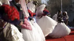 Sejumlah pasangan pengantin baru ikut ambil bagian dalam upacara pernikahan massal di tengah-tengah Festival Es dan Salju Harbin di provinsi Heilongjiang, China, Rabu (6/1/2016). ( REUTERS/ Aly Song)