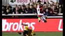 Duel pemain Arsenal, Alexis Sanchez (atas) menghindari terjangan pemain Sutton United, Kevin Amankwaah pada putaran kelima Piala FA di Gander Green Lane stadium, London; (20/2/2017). Arsenal menang 2-0. (AP/Matt Dunham)