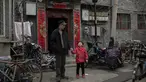 Seorang kakek bersama cucunya berbincang di halaman di luar rumah mereka di daerah hutong di Beijing (26/2). Hutong adalah jenis jalan sempit atau gang yang biasanya dikaitkan dengan kota-kota Cina utara, terutama Beijing.  (AFP Photo/Nicolas Asfouri)