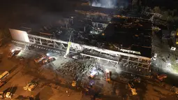 Petugas pemadam kebakaran Layanan Darurat Negara Ukraina bekerja untuk memadamkan api di pusat perbelanjaan yang terbakar setelah serangan roket di Kremenchuk, Ukraina, Senin malam (27/6/2022)malam. (AP Photo/Efrem Lukatsky)