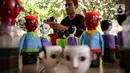 Chairuddin (40) bersama rekannya menyelesaikan pembuatan ondel-ondel dari botol bekas di Sanggar Rumah Kreasi, Jakarta, Minggu (13/6/2021). Botol bekas dimanfaatkan menjadi ondel-ondel untuk dijual dengan harga sepasang Rp35 ribu dan bisa membuat ratusan setiap harinya. (Liputan6.com/Johan Tallo)