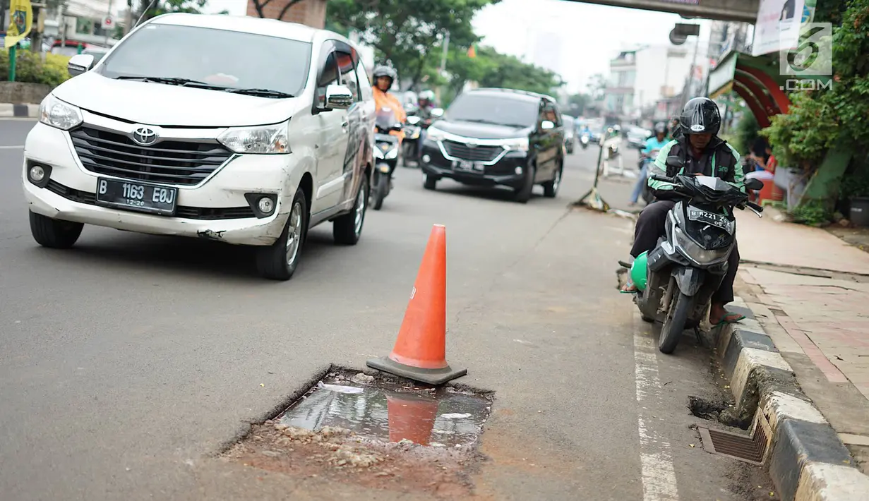 Kendaraan melintas di samping bekas galian proyek yang tidak tuntas pengerjaannya di Jalan Margonda Raya, Depok, Jawa Barat, Kamis (9/5/2019). Kondisi jalan yang diabaikan selama beberapa bulan terakhir tersebut memersempit dan mengganggu aktivitas warga. (Liputan6.com/Immanuel Antonius)