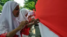 Sejumlah warga saat mengikuti lomba menjahit bendera Merah Putih sepanjang 500 meter di Kelurahan Pekojan, Jakarta, Minggu (16/8/2015). Lomba yg di ikuti oleh 12 RW dan 144 RT ini mengirimkan lima orang dlm setiap Rtnya. (Liputan6.com/Panji Diksana)