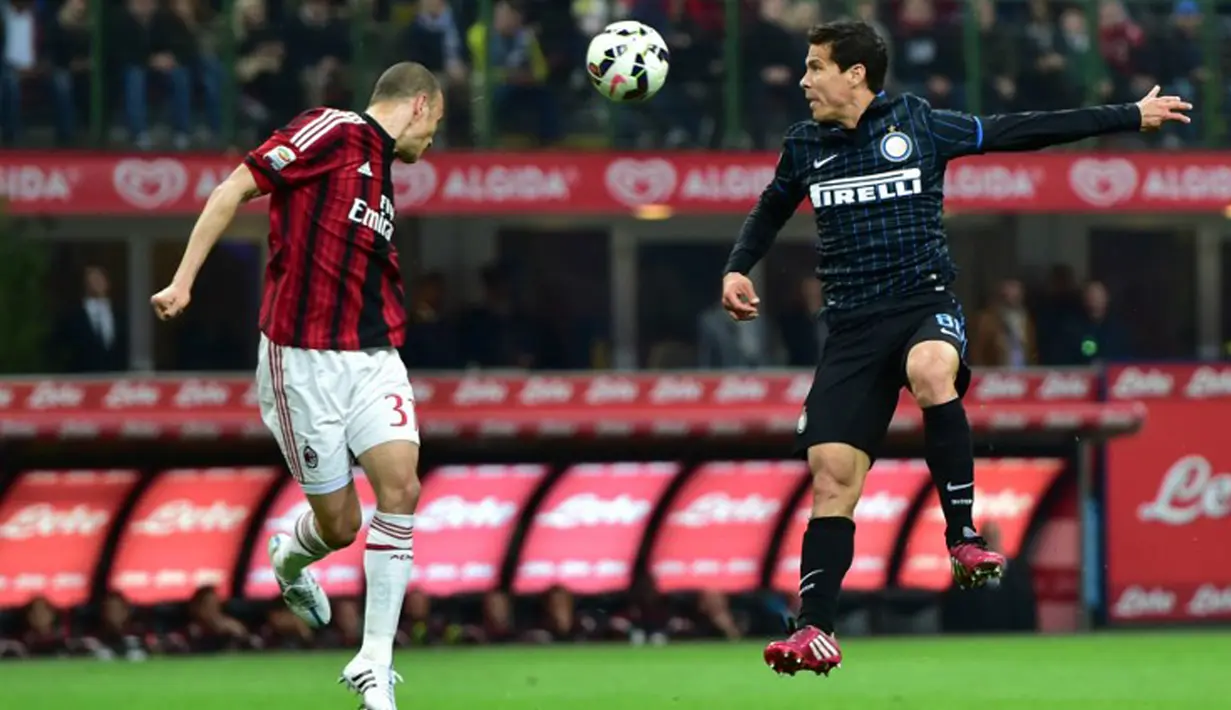 Gelandang Inter Milan, Hernanes (kanan) berebut bola udara dengan pemain AC Milan pada laga serie A di Stadio Giuseppe Meazza, Senin (20/4/2015). Inter Milan bermain imbang 0-0 dengan AC Milan. (AFP PHOTO/Giuseppe Cacace)