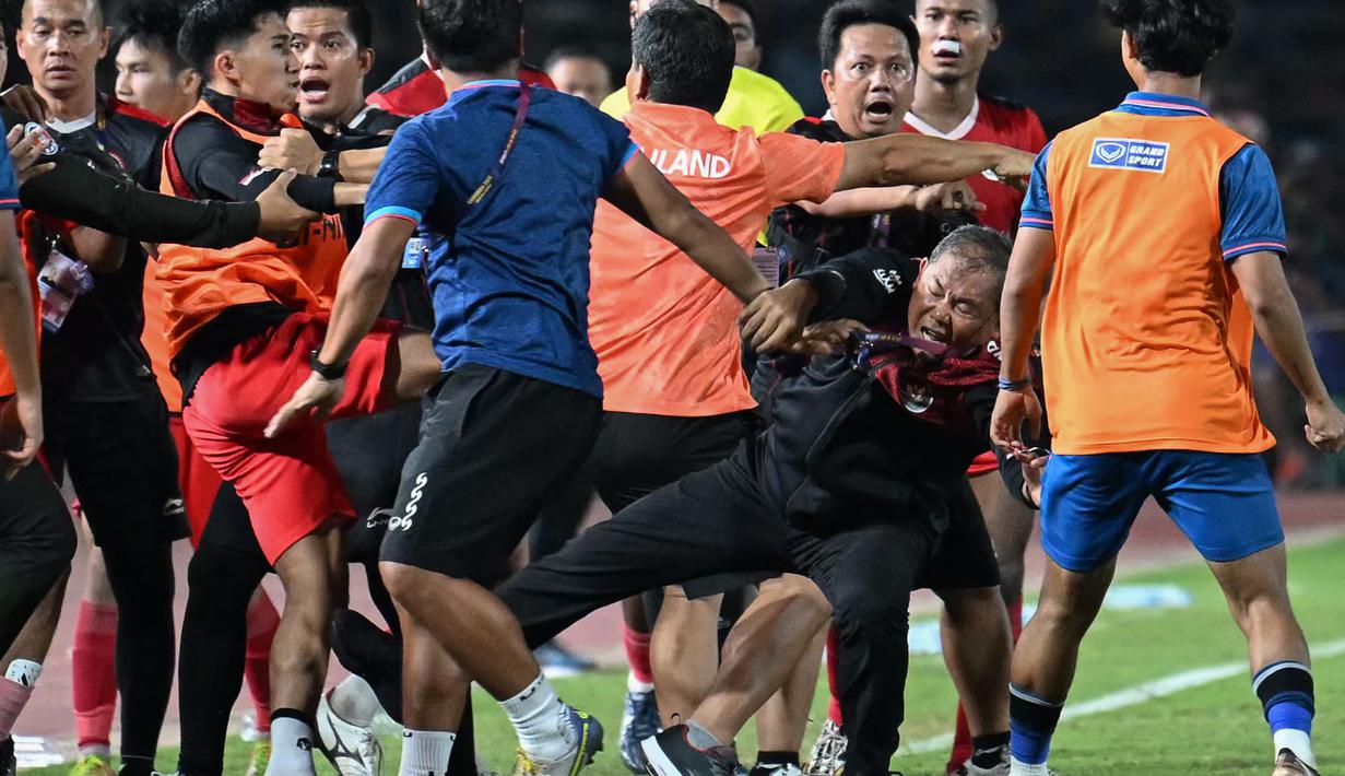 Manajer Timnas Indonesia U-22, Sumardji (tengah kanan) dikeroyok oleh official Timnas Thailand U-22 pada laga final SEA Games 2023 di Olympic Stadium, Phnom Penh, Kamboja, Selasa (16/05/2023). (AFP/Mohd Rasfan)