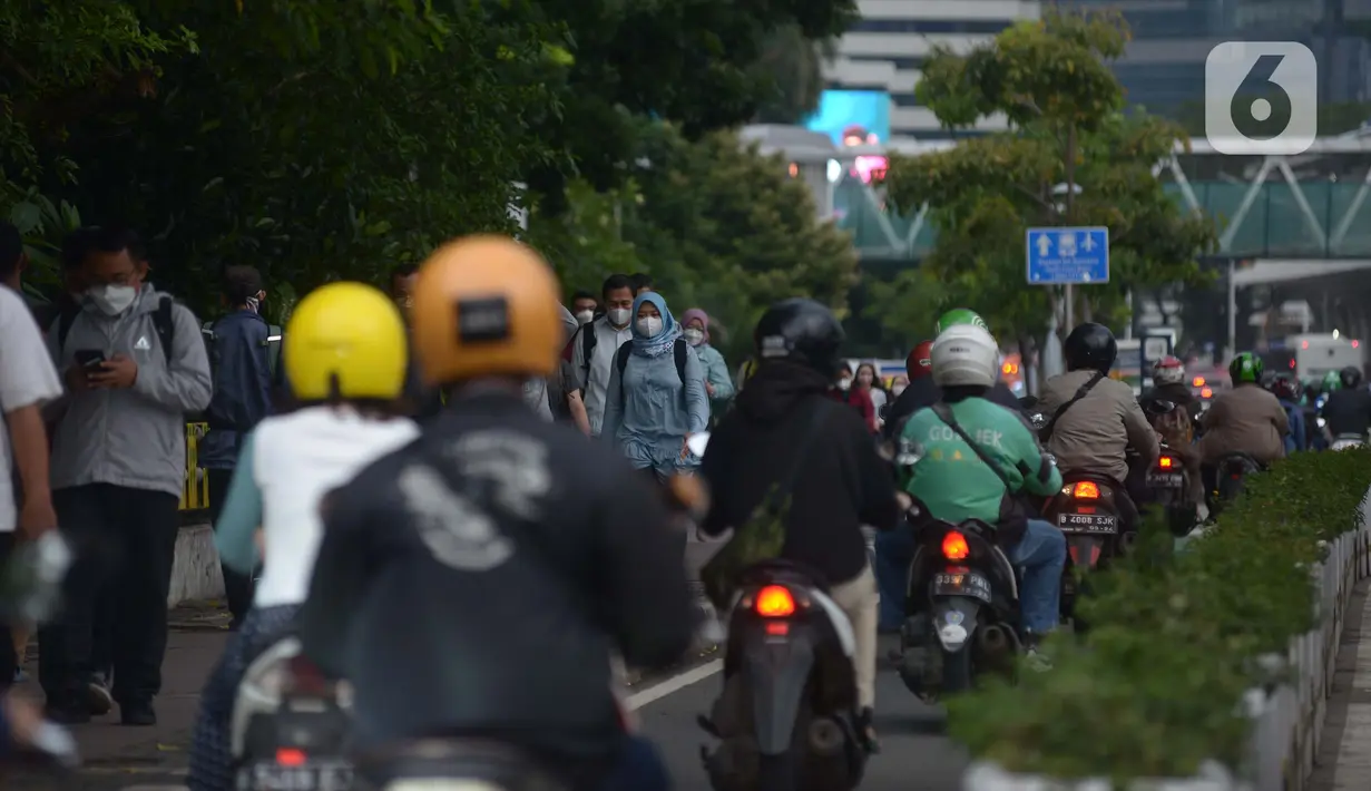 Karyawan perkantoran berjalan kaki  bergegas pulang di Kawasan Sudirman, Jakarta, Rabu (30/11/2022). Keputusan Pemerintah Provinsi (Pemprov) DKI Jakarta menaikan upah minimum provinsi (UMP) DKI  pada 2023 sebesar 5.6 persen menjadi Rp 4,9 juta . ditolak pengusaha dan buruh. (merdeka.com/Imam Buhori)