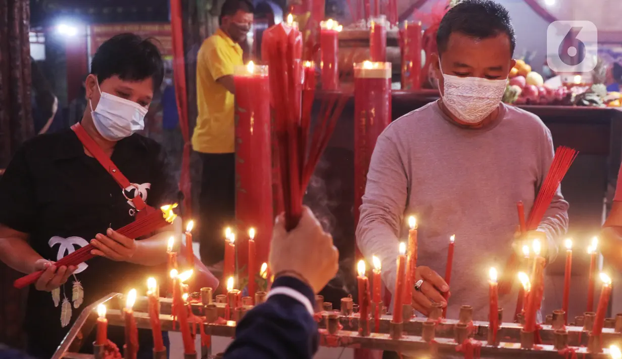 Warga keturunan Tionghoa melakukan sembahyang malam Imlek di Klenteng Boen San Bio, Tangerang, Kamis (11/2/2021). Meskipun di tengah pandemi Covid 19, sembahyang Imlek 2572 dilakukan dengan protokol kesehatan yang cukup ketat dan membatasi jumlah warga yang sembahyang. (Liputan6.com/Angga Yuniar)