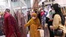Pengunjung melihat produk yang di jual saat bazar Ramadhan Persatuan Istri Anggota di Lobby Nusantara III, Senayan, Jakarta, Selasa (19/4/2022). Bazar Ramadhan ini menampilkan berbagai produk UMKM binaan seperti Kaus, kebaya, batik, aksesoris, busana muslim.  (Liputan6.com/Angga Yuniar)