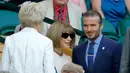 Mantan pemain Manchester United, David Beckham mencari tempat duduk untuk menyaksikan pertandingan pada hari kelima Kejuaraan Wimbledon 2017 di The All England Lawn Tennis Club di Wimbledon, London barat daya, Inggris (7/7). (AP Photo/Alastair Grant)