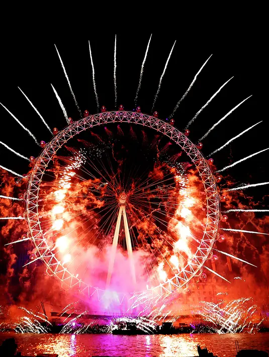 Kembang api menghiasi London Eye saat perayaan malam Tahun Baru 2019 di London, Inggris, Selasa (1/1). (AP Photo/Kirsty Wigglesworth)