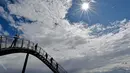Orang-orang berjalan di sebuah instalasi tangga melingkar "Tiger and Turtle" di Duisburg, 30 April 2018. Jalan setapak menyerupai roller coaster dengan tinggi 21 meter ini dibangun oleh seniman Jerman, Heike Mutter dan Ulrich Genth. (AP/Martin Meissner)