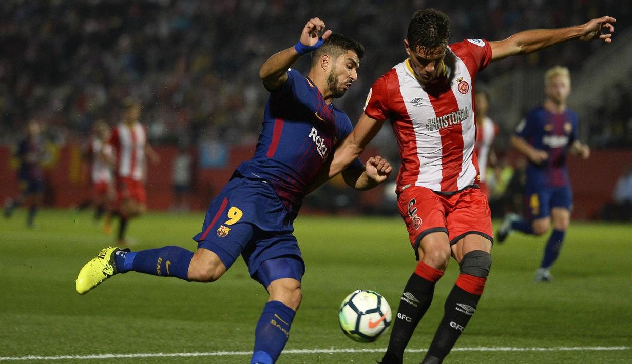 Striker Barcelona, Luis Suarez, berusaha melewati bek Girona, Bernardo Espinosa, pada laga La Liga Spanyol di Stadion Montilivi, Girona, Sabtu (23/9/2017). Girona kalah 0-3 dari Barcelona. (AFP/Josep Lago)