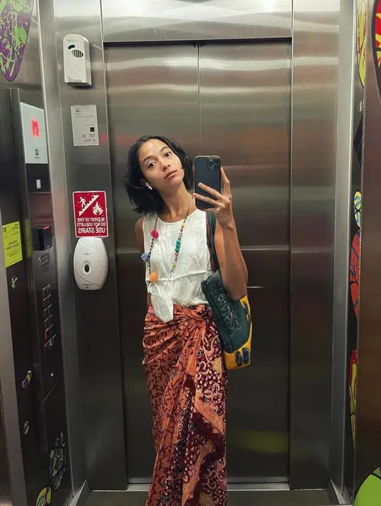 1. Seperti potret ini, Putri Marino tampak memadukan sleeveless blouse putih dengan kain batik warna merah. Gayanya jadi makin terlihat chic dengan aksesori kalung warna-warni. (Instagram/putrimarino).