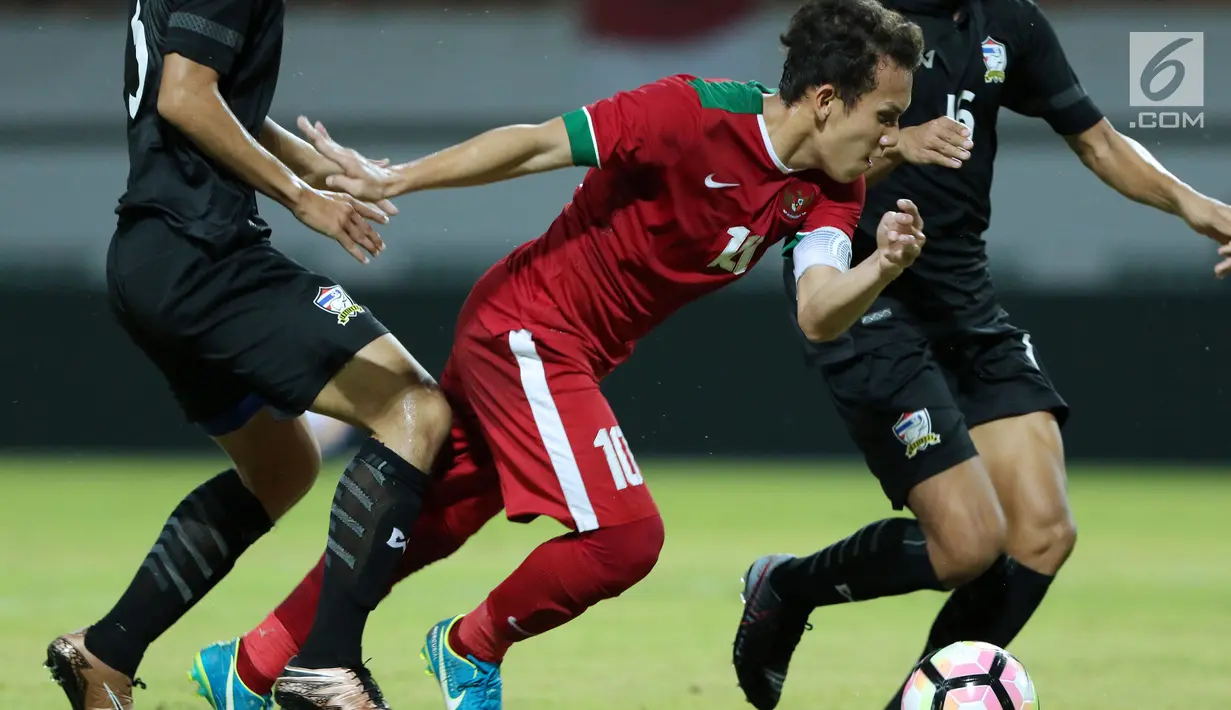 Pemain depan Indonesia U-19, Egy Maulana Vikri mencoba melewati kawalan pemain Thailand U-19 di Stadion Wibawa Mukti, Cikarang, Minggu (8/10). Egy satu-satunya remaja Asia Tenggara yang masuk daftar 60 remaja terbaik. (Liputan6.com/Helmi Fithriansyah)