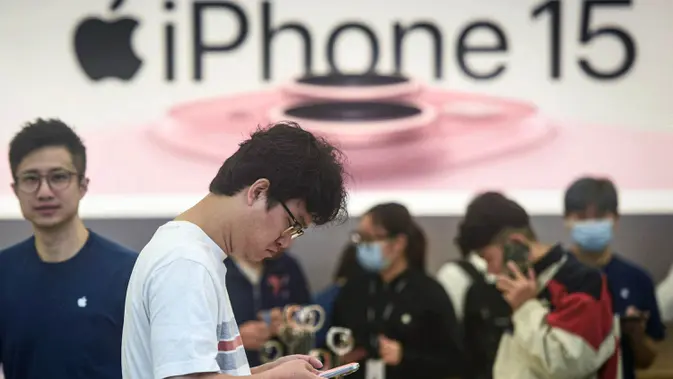 Seorang laki-laki mencoba ponsel iPhone 15 nan baru saja diluncurkan di sebuah toko Apple di Hangzhou, di provinsi Zhejiang, China pada 22 September 2023. (AFP/China OUT)