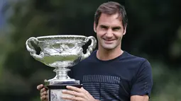 Petenis Swiss, Roger Federer tersenyum saat berpose dengan Piala Challenge Norman Brookes di Government House, Melbourne, Australia (29/1). Federer mengalahkan petenis Kroasia Marin Cilic 6-2, 6-7(5), 6-3, 3-6, 6-1. (AP Photo/Dita Alangkara)