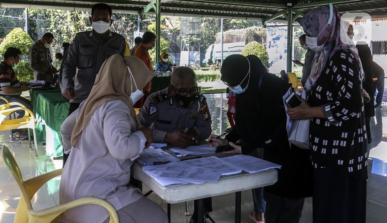 Petugas melakukan pendataan kepada warga saat pelaksanaan vaksinasi booster COVID-19 di Taman Pemuda Pratama, Depok, Jawa Barat, Kamis (7/4/2022). Menteri Kesehatan Budi Gunadi Sadikin mengingatkan syarat yang harus dipenuhi untuk mudik Lebaran 2022. (Liputan6.com/Johan Tallo)