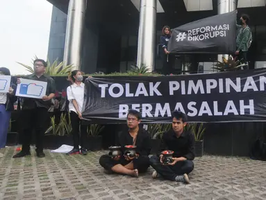 Aktivis dari Indonesia Corruption Watch (ICW) melakukan aksi teatrikal menolak kehadiran pimpinan KPK bermasalah di depan Gedung Merah Putih KPK, Jakarta, Jumat (20/12/2019). Aksi penolakan digambarkan dengan keberadaan dua dukun yang tengah mengusir roh jahat. (merdeka.com/Dwi Narwoko)