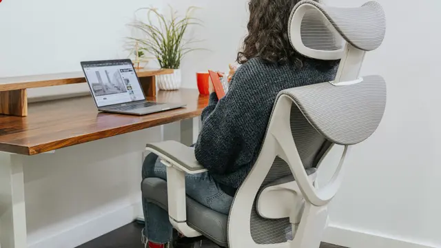 Ilustrasi pekerja kantoran bekerja dengan nyaman menggunakan kursi ergonomis.